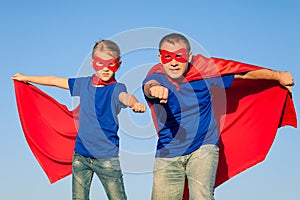 Father and daughter playing superhero at the day time.