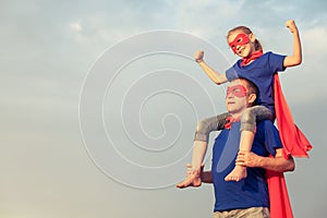 Father and daughter playing superhero at the day time.