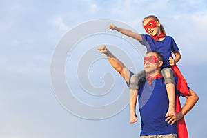 Father and daughter playing superhero at the day time.