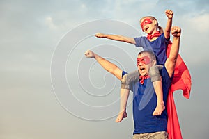 Father and daughter playing superhero at the day time.