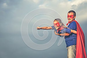 Father and daughter playing superhero outdoors at the day time.