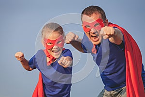 Father and daughter playing superhero outdoors at the day time.