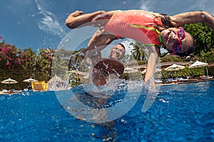 Father and daughter playing in a swimming pool