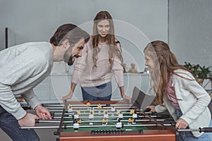 father and daughter playing table soccer
