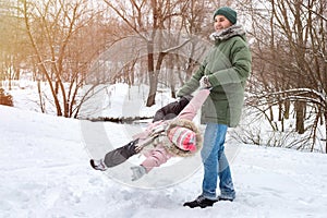 Father with daughter plays in the winter park.  Happy family on winter vacation