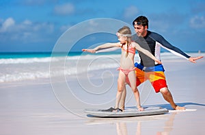 Father and daughter practicing surfing