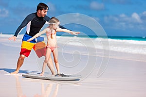 Father and daughter practicing surfing