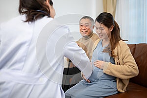Father and daughter pregnant woman visit gynecologist doctor at medical clinic for pregnancy consultant. Doctor examine pregnant