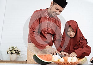 Father and daughter prepare fruits to breaking fast