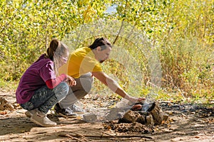 Father and daughter preparing dinner over fire