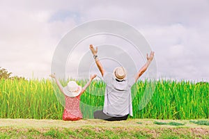 Father and daughter raise both hands in the middle of pure nature