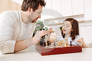 Father and daughter setting up a chessboard