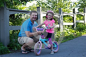 Father and daughter sharing a happy moment while learning to rid