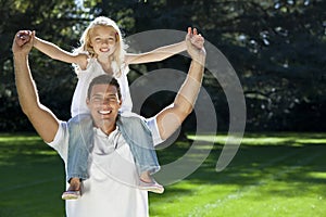 Father With Daughter On Shoulders In A Park