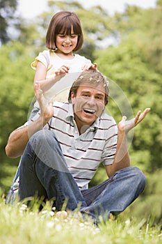 Father and daughter sitting outdoors with flowers
