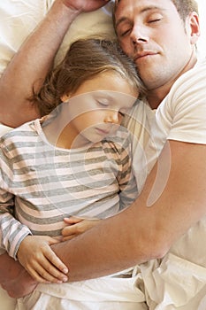 Father And Daughter Sleeping In Bed