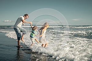 Father, daughter and son playing on the beach