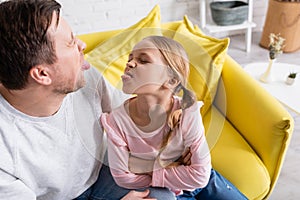 father and daughter sticking out tongues