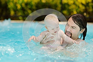 Father and daughter swimming in pool