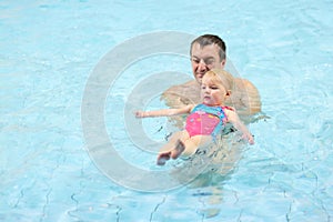 Father and daughter in swimming pool