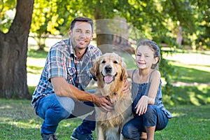 Father and daughter with their pet dog in the park