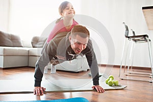 Father and daughter are training at home. Workout in the apartment. Sports in home conditions. They make the doing plank