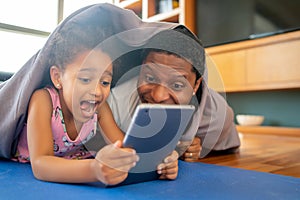 Father and daughter using digital tablet at home. photo