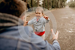 Father and daughter walk in the rain in the park, the emotions of the child, wet clothes