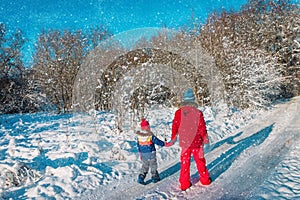 Father with daughter walk in winter forest