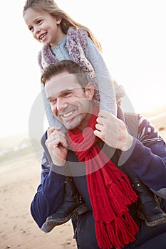 Father And Daughter Walking On Winter Beach