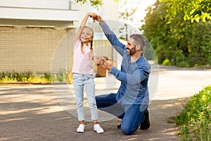 Father-daughter waltz. Happy loving dad and his child girl dancing outdoors while walking in park