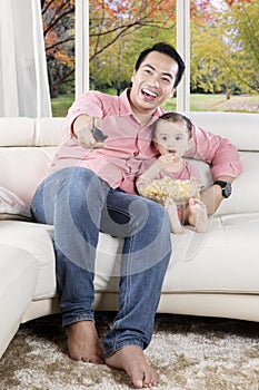 Father and daughter watch funny movies on tv