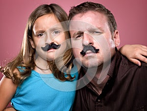 Father and Daughter Wearing Fake Mustaches