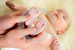 Father doctor massaging baby foot photo
