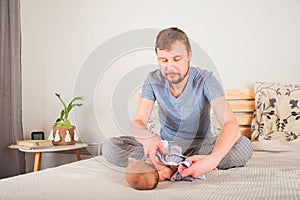 Father dresses a newborn in the bedroom. Clothes baby undershirts and sliders on a baby close-up and copy space. Home care and bab