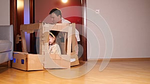 Father Driving Lovely Daughter in Cardboard Car. Dad and Girl Racing Together