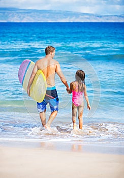 Father and Duagher on the Beach Going Surfing