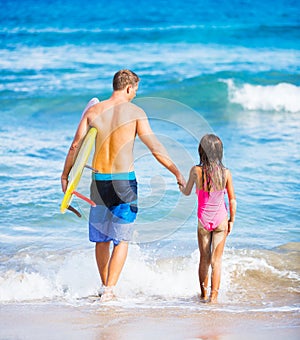 Father and Duagher on the Beach Going Surfing