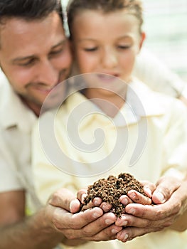 Father educate son to care a soil photo