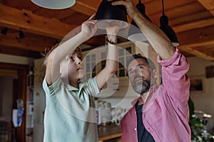 Father explaining led bubls to son, teaching him about energy efficiency, longevitiy and environmental impact. Changing