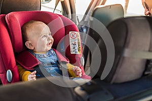 Father fasten his baby in car seat