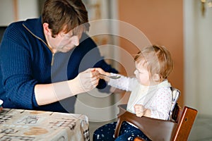 Father feeding baby girl from spoon mashed vegetables and puree. food, child, feeding and people concept -cute toddler