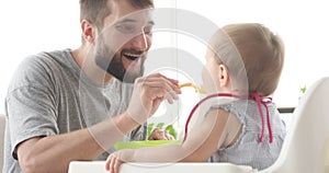 Father feeding cute baby daughter