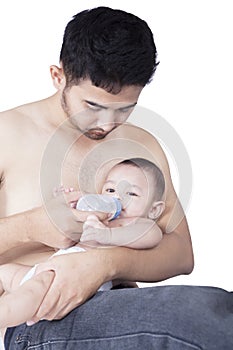 Father feeding his baby with bottle of milk