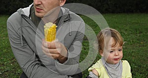 Father feeding his baby with a corn