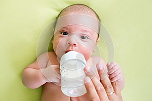 Father feeding his baby infant from bottle