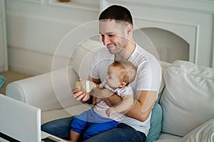 Father feeding his little son from bottle