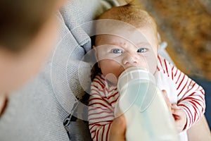 Father feeding newborn baby daughter with milk in nursing bottle