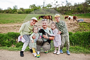 Father with four kids on an animal eco farm hold baby sheep lamb in hand