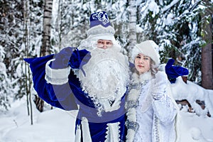 Father Frost with a bag of gifts and a Snow Maiden in the forest.  Winter, December. Russian Christmas characters Ded Moroz
